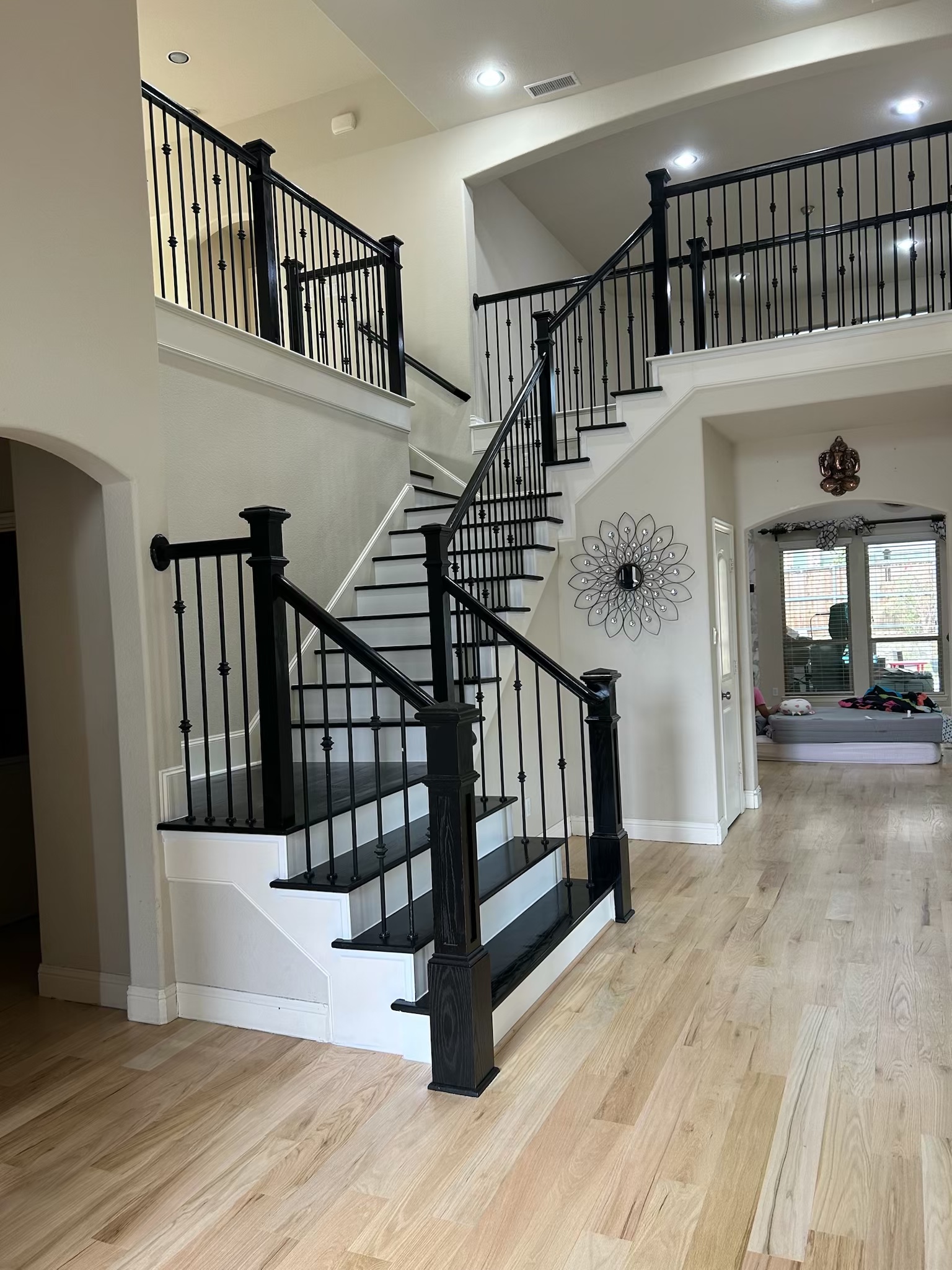 Hardwood staircase with ebony steps and color matched railing with a white stained finish flooring